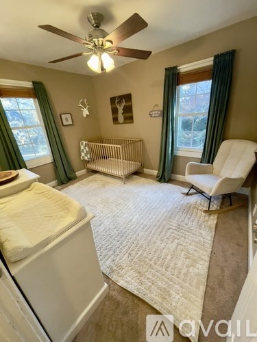 A bedroom with a white bed and a white chair.