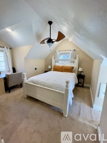 A bedroom with a bed, nightstand, and window.