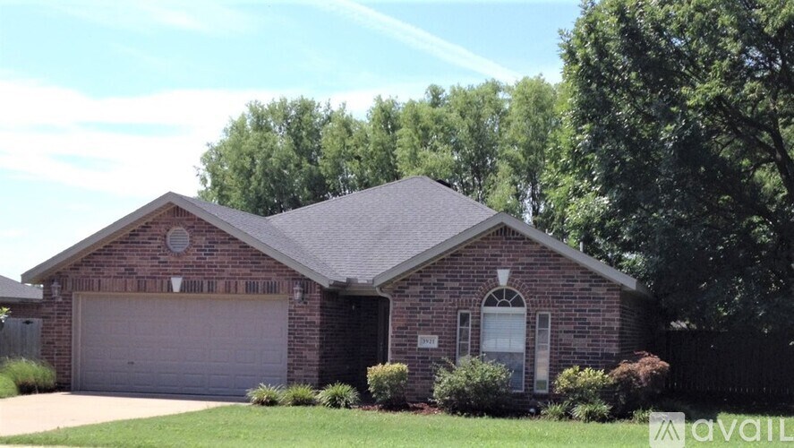 A house with a garage and a window is surrounded by greenery.