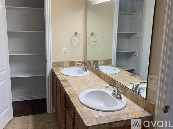 A bathroom with two sinks and a large mirror.