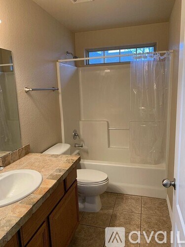 A bathroom with a toilet, sink, and bathtub.
