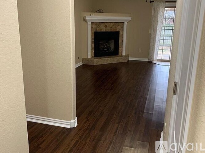 A living room with a fireplace and wood flooring.