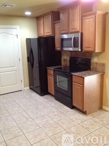 A kitchen with black appliances and wooden cabinets.
