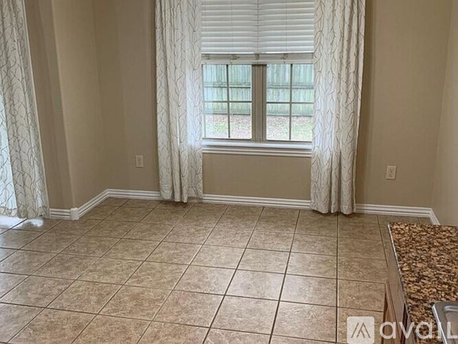 A room with a window and a tiled floor.