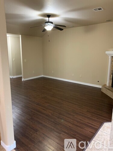 A room with wooden floors and a ceiling fan.