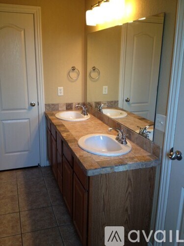A bathroom with two sinks and a mirror.
