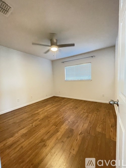 A room with wooden flooring and a ceiling fan.