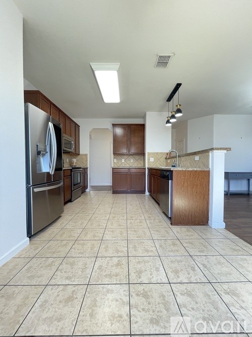 A kitchen with tile flooring and wooden cabinets.