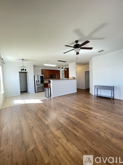 A room with wooden flooring and a ceiling fan.