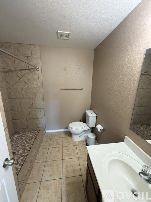 A bathroom with a toilet, sink, and shower.