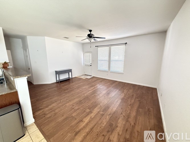 A room with wooden flooring and a ceiling fan.