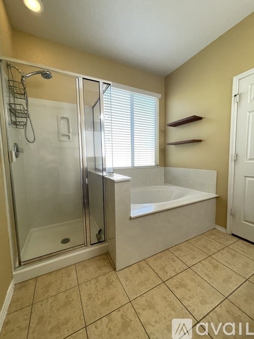 A bathroom with a glass shower door and a bathtub.