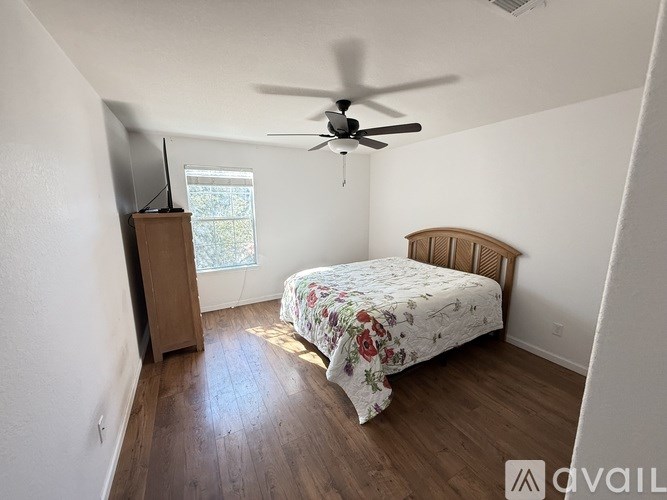 A bedroom with a bed, dresser, and television.
