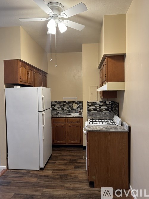 A kitchen with a white refrigerator and wooden cabinets.