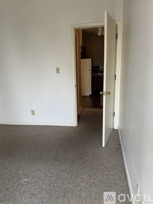 A room with a carpeted floor and a doorway leading to another room.