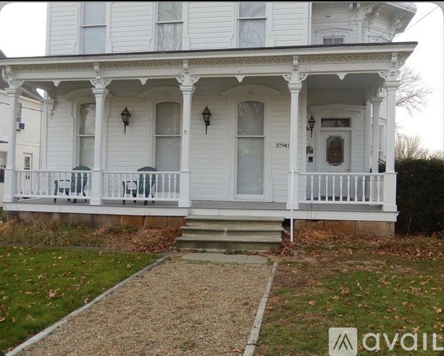 A white house with a porch and a sign that says "available".