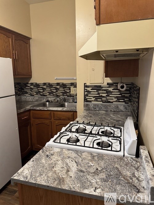 A kitchen with a white gas stove and a granite countertop.