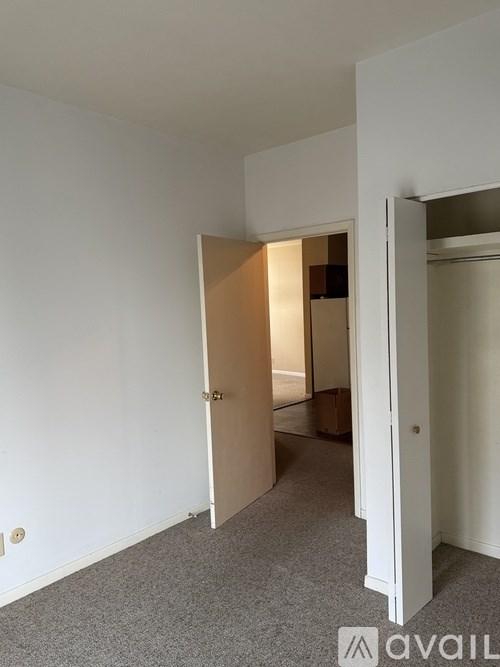 A room with a carpeted floor and a doorway leading to another room.
