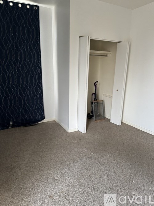 A room with a carpeted floor and a doorway leading to another room.