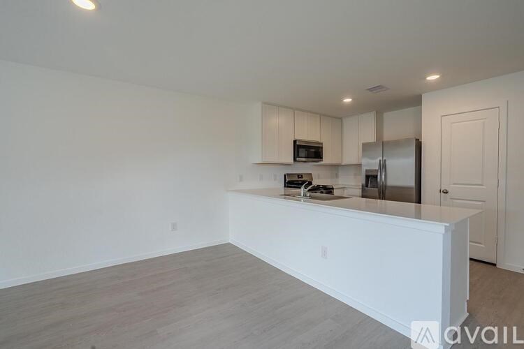 A kitchen with white cabinets and a stainless steel refrigerator.