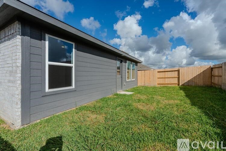 A grey house with a window and a door is for sale.