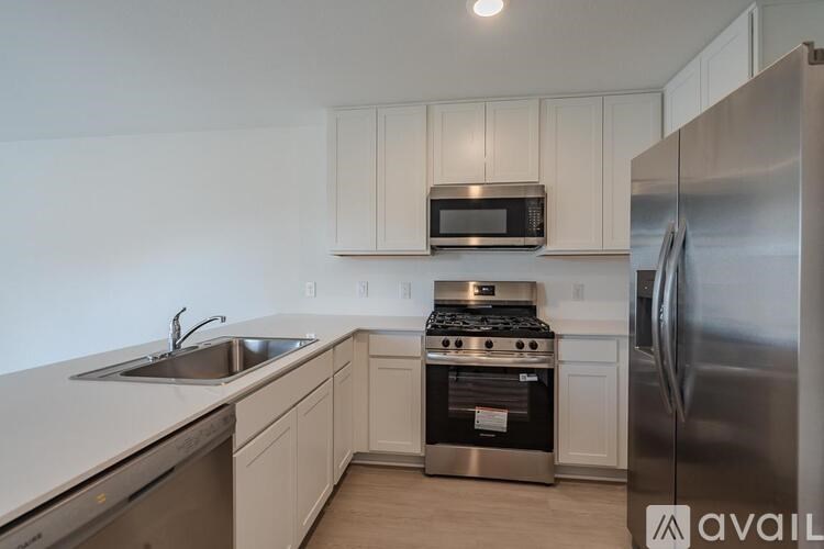 A kitchen with white cabinets and a stainless steel refrigerator.