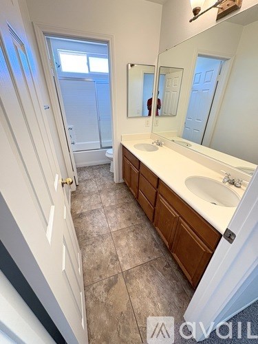 A bathroom with a sink, mirror, and tiled floor.