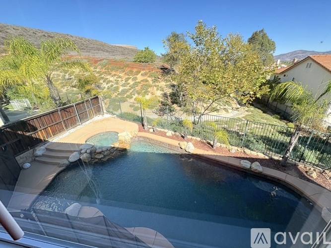 A pool with a waterfall and a mountain in the background.
