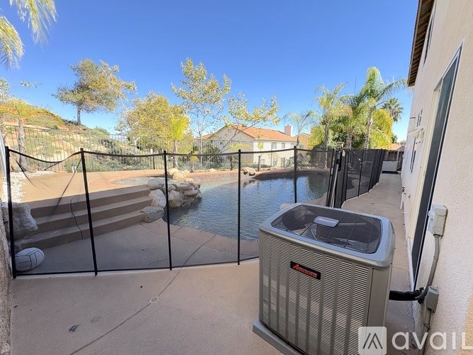 A pool with a fence and a wall-mounted air conditioner.