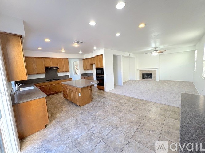 A spacious kitchen with wooden cabinets and a tiled floor.