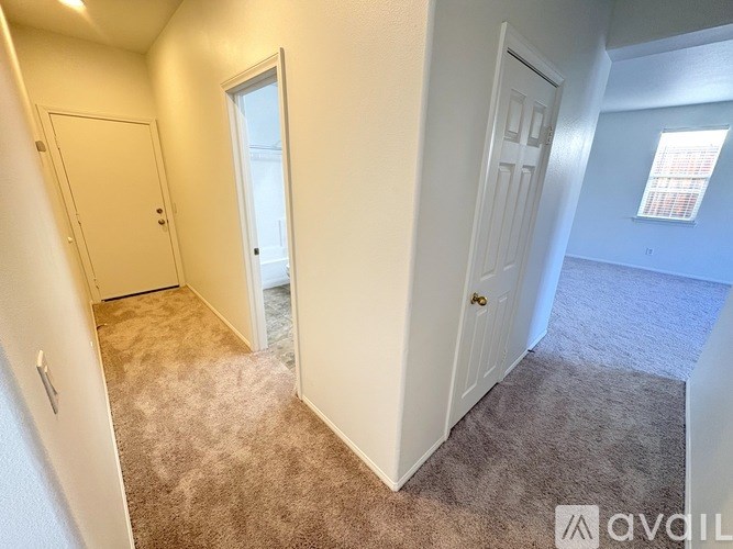 A carpeted room with a door and a window.