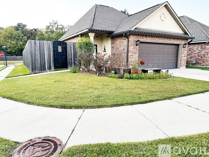 A house with a grey garage door and a wooden fence.