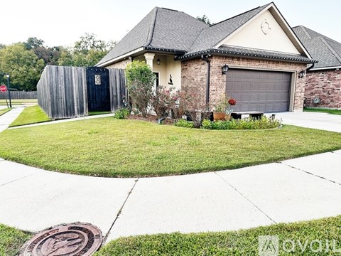 A house with a grey garage door and a wooden fence.