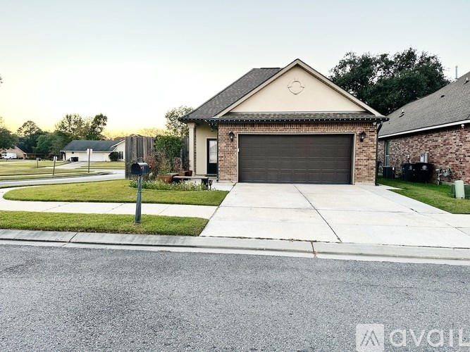 A house with a garage and a driveway in front of it.