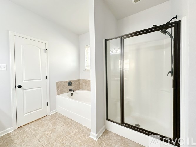A white bathroom with a glass shower door.