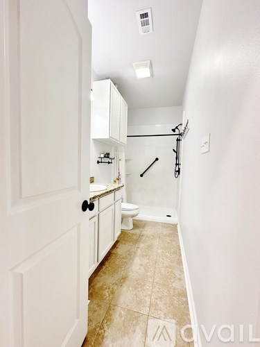 A bathroom with a toilet, sink, and a cabinet.