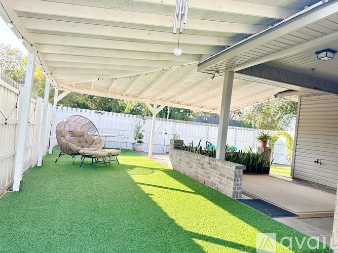A covered backyard with a lawn and a patio.