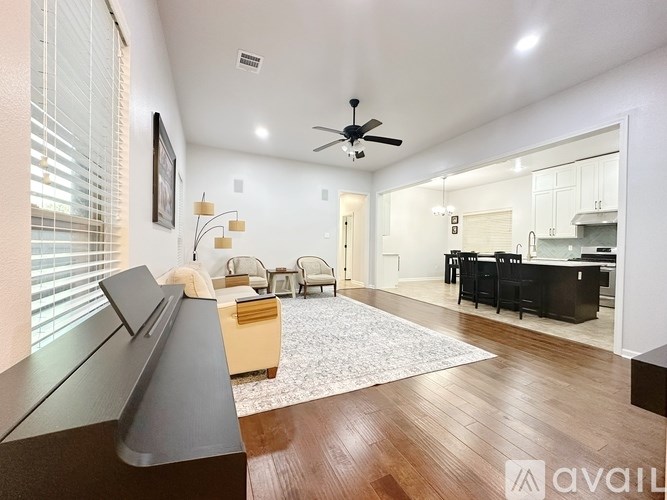 A living room with a wooden floor and a ceiling fan.