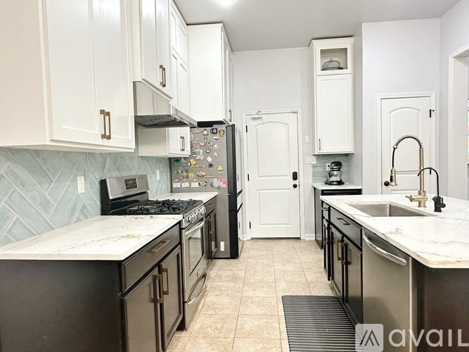A kitchen with black and white cabinets and appliances.