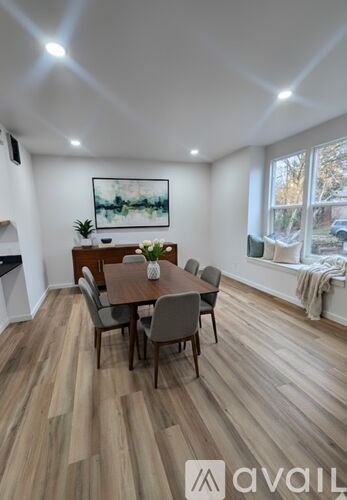 A dining room with a wooden table and chairs.