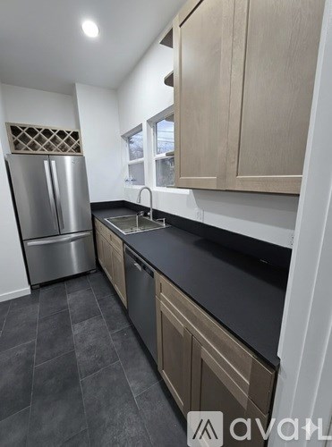 A kitchen with wooden cabinets and a stainless steel refrigerator.