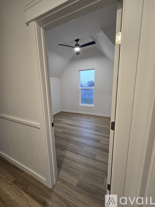 A room with a ceiling fan and a window.