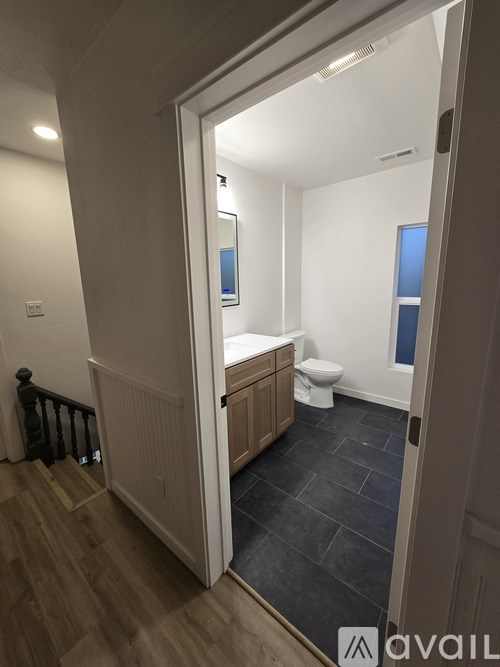 A bathroom with a toilet, sink, and mirror.