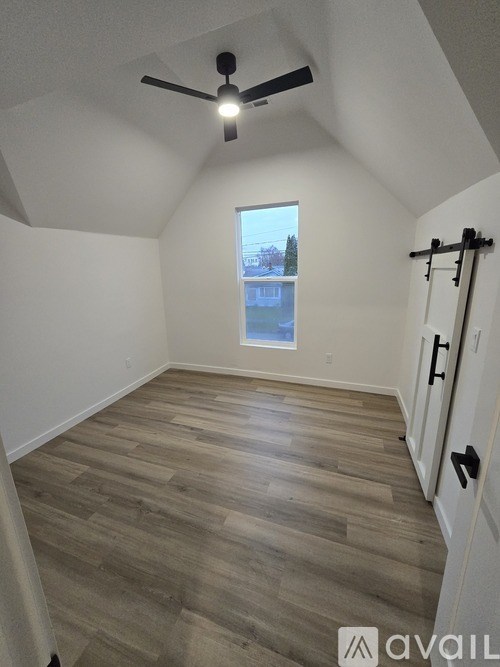 A room with a ceiling fan and a window overlooking a snowy landscape.