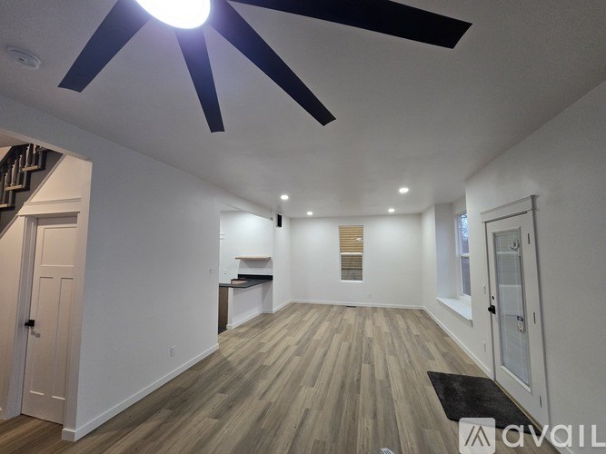 A room with a ceiling fan and wooden flooring.