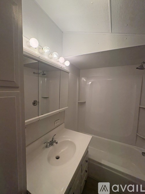 A bathroom with a white sink and a white bathtub.