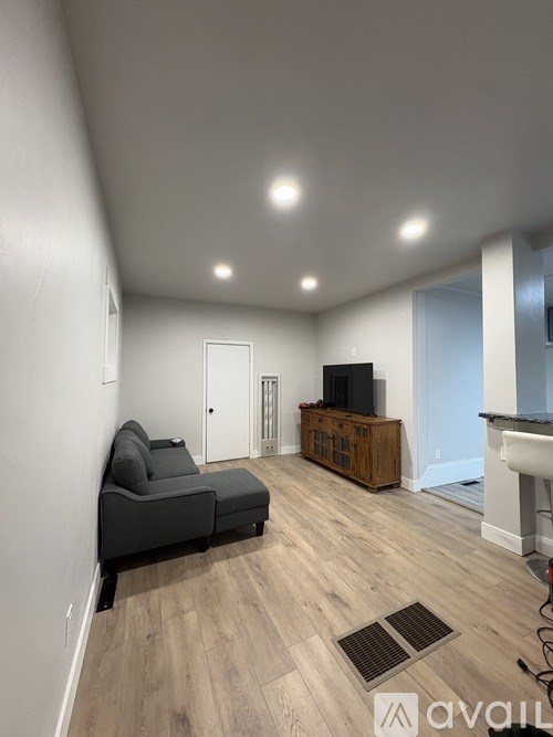 A living room with a grey couch and a wooden cabinet.
