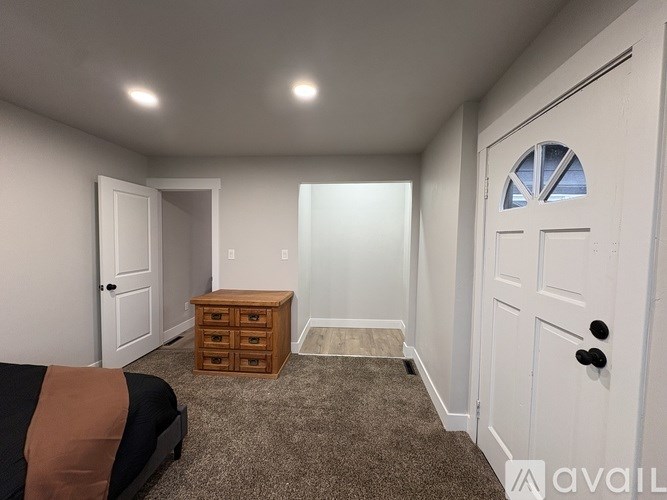 A bedroom with a bed, dresser, and window.
