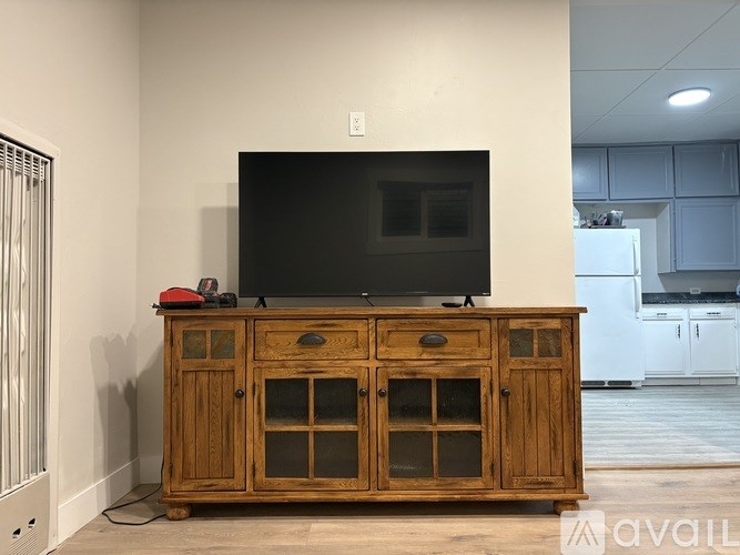 A wooden cabinet with a flat screen TV on top of it.