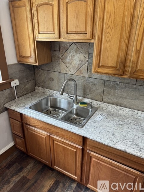 A kitchen with wooden cabinets and a granite countertop.